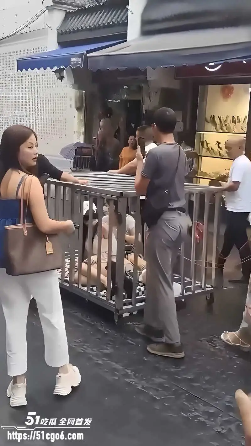 湖南汨罗商业街 惊现活人浸猪笼 俩女一狗被关铁笼 敲锣游街太疯狂！ 图5