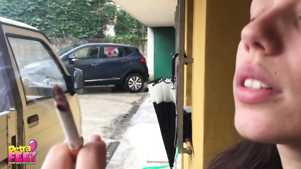 漂亮的黑发女郎在户外抽烟