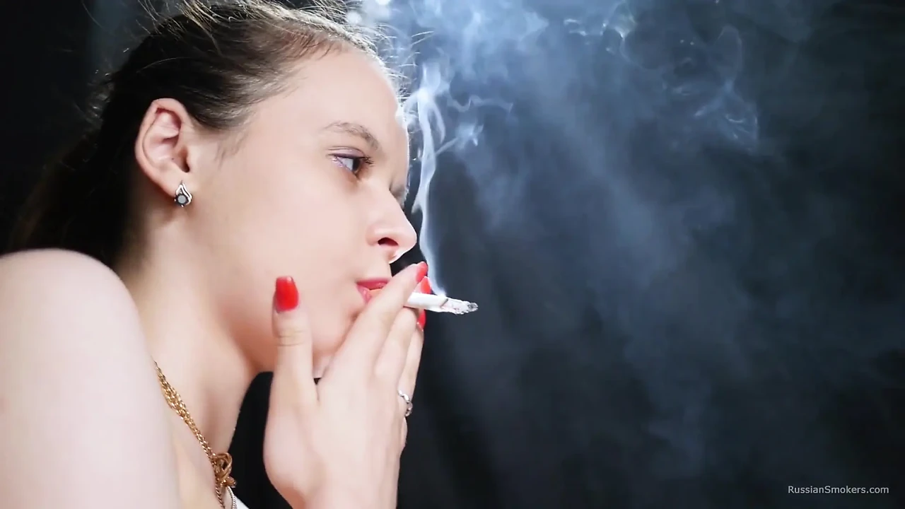 赤裸上身的黑发女郎在戏剧性的烟雾中吸烟