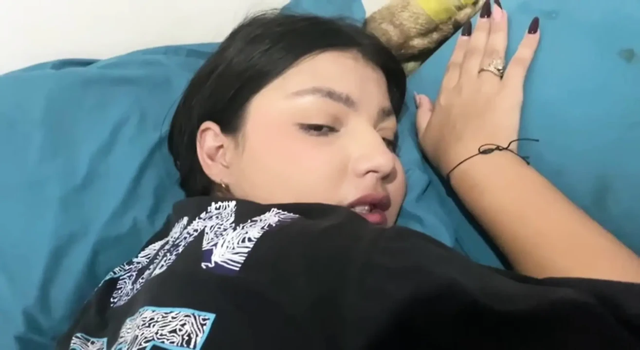 业余智能手机拍摄的年轻女人在一张白床上，在一间光线充足的现代卧室里。她在中央