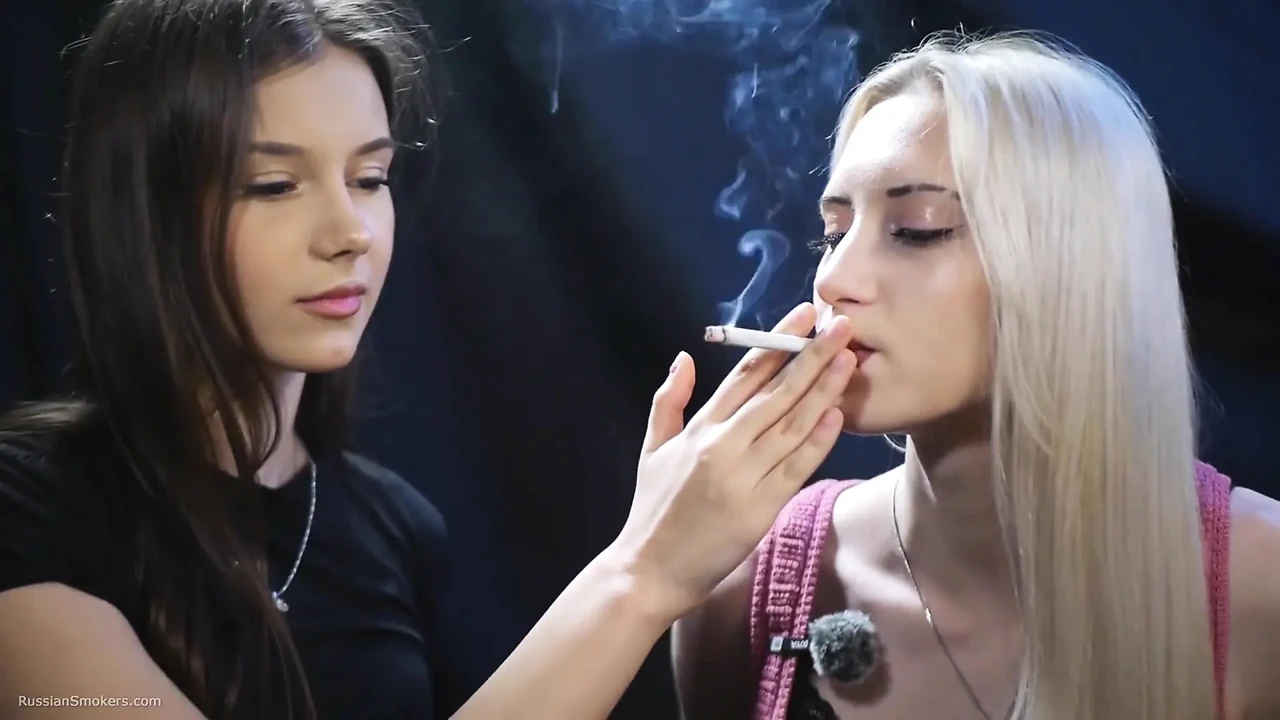 两个女孩在缓慢亲密的吸烟中分享香烟